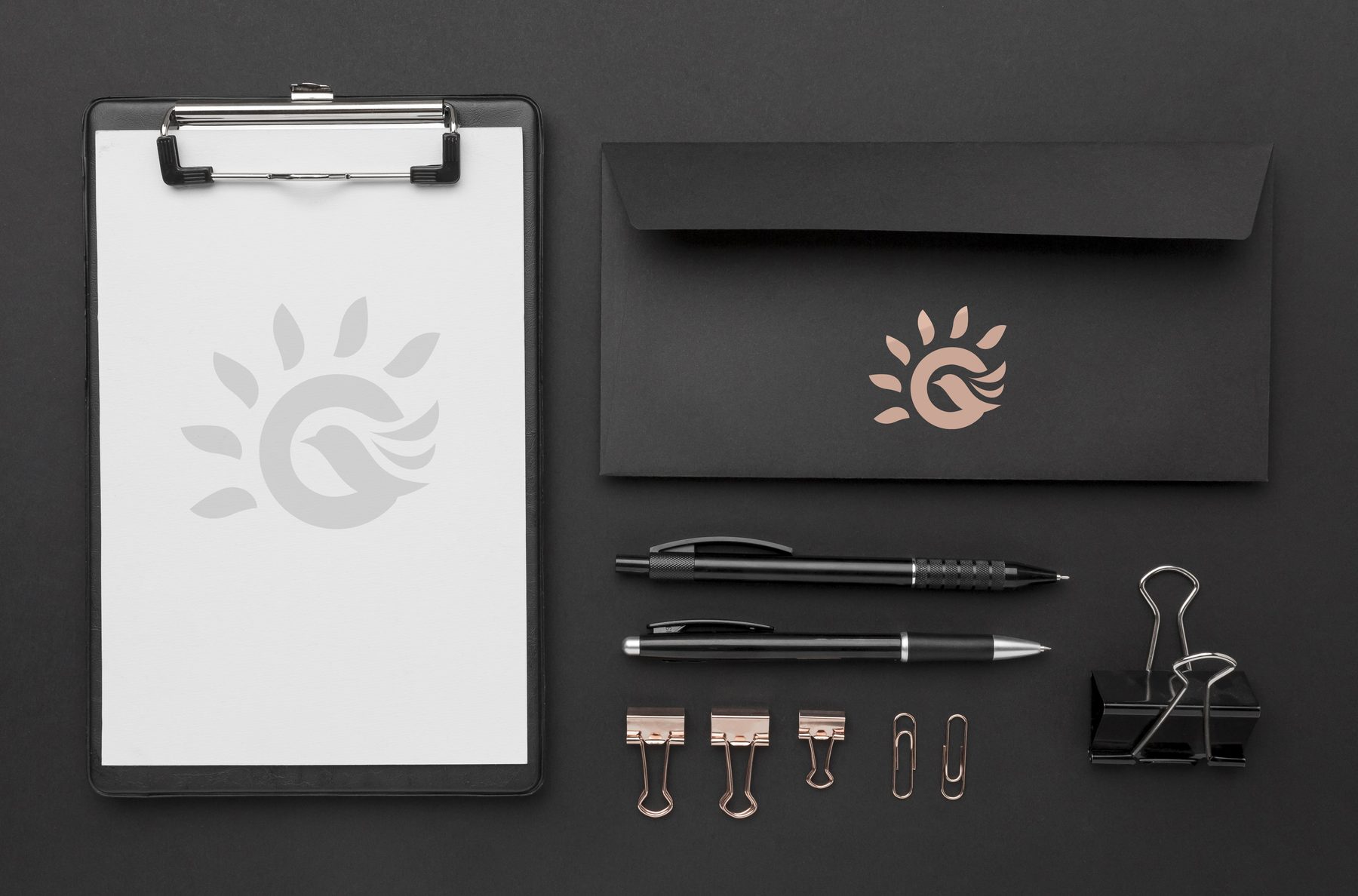 OCS branded stationery — a clipboard, black envelope and pens carrying the emblem.