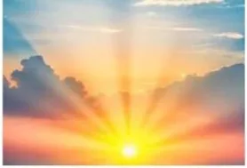 A rising sun breaking through clouds