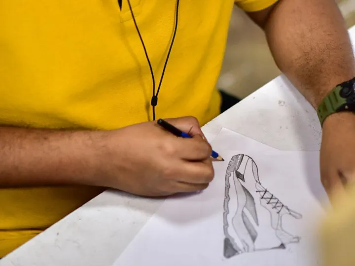 Hand sketching a running shoe in pencil